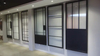 Moderna puerta corrediza de vidrio con marco de acero negro y herrajes
