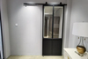 Puerta corrediza de granero con acabado de metal negro y vidrio esmerilado con kit de herrajes
